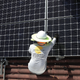 A worker installs a solar panel on a home in Palmetto Bay, Florida.